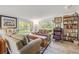 Bright living room with plank floors, eclectic furnishings, and large sun-filled windows at 416 Western Rd, New Smyrna Beach, FL 32168