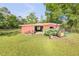 Spacious red outbuilding on a well-kept lot with a tractor at 416 Western Rd, New Smyrna Beach, FL 32168