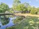 Picturesque pond reflecting the house and trees creating a tranquil outdoor setting at 416 Western Rd, New Smyrna Beach, FL 32168
