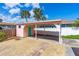 This home's carport features a bright teal door and a gravel lot for easy parking at 4262 Cardinal Blvd, Port Orange, FL 32127