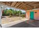 View from inside carport shows gravel, a teal door and palm trees at 4262 Cardinal Blvd, Port Orange, FL 32127