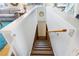 An interior view of a staircase leading down to a living area, showcasing wooden steps and a handrail at 4262 Cardinal Blvd, Port Orange, FL 32127