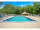 Community pool with lounging area, picnic pavilion, and lush mature trees surrounding the perimeter at 4307 Sea Mist Dr # 135, New Smyrna Beach, FL 32169