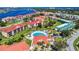 Aerial view of a community with beautiful pool, red roofs, and lush green landscaping by the water at 438 Bouchelle Dr # 104, New Smyrna Beach, FL 32169