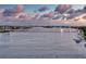 Aerial view of a bridge over water with waterfront condos, boats, and a cloudy sky at 438 Bouchelle Dr # 104, New Smyrna Beach, FL 32169