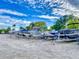 Outdoor boat storage area with various boats on trailers under a bright sky with fluffy clouds at 438 Bouchelle Dr # 104, New Smyrna Beach, FL 32169