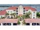 Beautiful waterfront condominium with red tile roof and lush palm trees at 438 Bouchelle Dr # 104, New Smyrna Beach, FL 32169