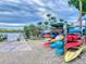 Colorful kayaks are stacked on a rack near a wooden pier along a river at this community at 438 Bouchelle Dr # 104, New Smyrna Beach, FL 32169