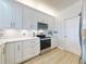 Bright kitchen featuring white cabinetry, stainless steel appliances, and tile backsplash at 438 Bouchelle Dr # 104, New Smyrna Beach, FL 32169