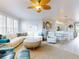 Bright open-concept living space with a white sectional, rattan rug, and adjacent dining area at 438 Bouchelle Dr # 104, New Smyrna Beach, FL 32169