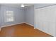 Clean bedroom featuring laminate flooring, a ceiling fan, a spacious closet, and a bright window at 4431 Doris Dr, New Smyrna Beach, FL 32169