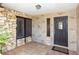 Charming front entryway with unique stonework, brick accents, tile flooring, and stylish wood door at 4431 Doris Dr, New Smyrna Beach, FL 32169