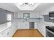 Bright kitchen features white cabinets, quartz countertops, stainless steel appliances, and ample countertop space at 4431 Doris Dr, New Smyrna Beach, FL 32169