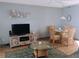 Cozy living room featuring a decorative turtle wall sculpture, a TV, and rattan furnishings at 4501 S Atlantic Ave # 5060, New Smyrna Beach, FL 32169