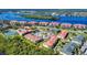 Wide aerial shot of condo buildings featuring red tile roofs and landscaping overlooking a river and nature preserve at 468 Bouchelle Dr # 128, New Smyrna Beach, FL 32169