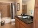 Full bathroom with tiled shower/tub combo, dark granite counters, and wood cabinets at 468 Bouchelle Dr # 128, New Smyrna Beach, FL 32169