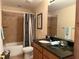 Full bathroom with tiled shower/tub combo, dark granite counters, and wood cabinets at 468 Bouchelle Dr # 128, New Smyrna Beach, FL 32169