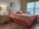 Bright bedroom features a decorative bed frame, wood-look flooring, and natural light from the window at 468 Bouchelle Dr # 128, New Smyrna Beach, FL 32169