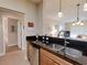 Efficient kitchen with dark countertops, stainless steel sink, and access to living and dining areas at 468 Bouchelle Dr # 128, New Smyrna Beach, FL 32169
