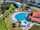 A beautiful aerial view of a heart shaped community pool surrounded by manicured landscaping and lounge chairs at 468 Bouchelle Dr # 128, New Smyrna Beach, FL 32169