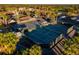 Aerial view of multiple tennis courts surrounded by lush landscaping, situated near the clubhouse and parking areas at 481 Sweet Bay Ave, New Smyrna Beach, FL 32168