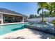 Beautiful backyard features an in-ground pool, spa, outdoor dining, and travertine patio at 481 Sweet Bay Ave, New Smyrna Beach, FL 32168