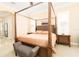 Elegant bedroom featuring a four-poster bed, plantation shutters, and neutral decor at 481 Sweet Bay Ave, New Smyrna Beach, FL 32168