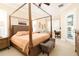 Spacious bedroom featuring a four-poster bed, plantation shutters, and a sitting area at 481 Sweet Bay Ave, New Smyrna Beach, FL 32168