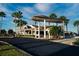 Beautiful clubhouse exterior with covered entrance, lush landscaping, and ample parking under a sunny blue sky at 481 Sweet Bay Ave, New Smyrna Beach, FL 32168