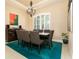 Elegant dining room featuring a modern chandelier, plantation shutters, and a table with seating for eight at 481 Sweet Bay Ave, New Smyrna Beach, FL 32168