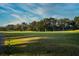Picturesque golf course featuring manicured greens, mature trees, and a blue flag in the distance at 481 Sweet Bay Ave, New Smyrna Beach, FL 32168