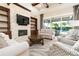 Living room with stone fireplace, custom built-ins, and sliding doors to the outdoor living space at 481 Sweet Bay Ave, New Smyrna Beach, FL 32168