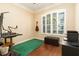 Well-lit home office with a modern desk setup, a guitar and a large window with plantation shutters at 481 Sweet Bay Ave, New Smyrna Beach, FL 32168