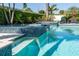 Sparkling in-ground pool and spillover spa with lush landscaping create a tropical oasis at 481 Sweet Bay Ave, New Smyrna Beach, FL 32168