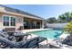The backyard features a luxurious pool with an attached spa and an outdoor patio dining area at 481 Sweet Bay Ave, New Smyrna Beach, FL 32168