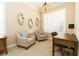 Cozy sitting room featuring two armchairs, a writing desk, and plantation shutters at 481 Sweet Bay Ave, New Smyrna Beach, FL 32168