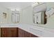 Modern bathroom with double sinks, white countertops, and wood cabinets at 5300 S Atlantic Ave # 14-202, New Smyrna Beach, FL 32169