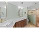 Bathroom with double sinks, a large mirror, and a separate glass-enclosed shower at 5300 S Atlantic Ave # 14-202, New Smyrna Beach, FL 32169