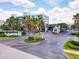 Gated community entrance with manicured landscaping, palm trees, and building views at 5300 S Atlantic Ave # 14-202, New Smyrna Beach, FL 32169