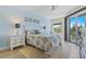 Inviting primary bedroom boasts natural light, a leafy bedspread, and private balcony entrance, creating a serene atmosphere at 5300 S Atlantic Ave # 14-202, New Smyrna Beach, FL 32169