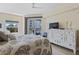 Spacious primary bedroom with a private balcony, a large dresser, and a leafy bedspread, offering comfort and style at 5300 S Atlantic Ave # 14-202, New Smyrna Beach, FL 32169