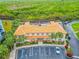 An aerial view displays building with parking, lush green space, and a tree-covered marshland at 5300 S Atlantic Ave # 16-205, New Smyrna Beach, FL 32169