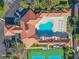 Drone picture of an outdoor clover-shaped pool, clubhouse, tennis courts, and common grounds at 5300 S Atlantic Ave # 16-205, New Smyrna Beach, FL 32169