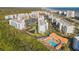 Beautiful aerial view of the condominium complex with a pool, lake, and easy beach access at 5300 S Atlantic Ave # 16-205, New Smyrna Beach, FL 32169