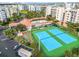 An aerial view showcases community amenities, including tennis courts, a pool, and shuffleboard, near the beach at 5300 S Atlantic Ave # 16-205, New Smyrna Beach, FL 32169