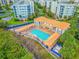 An aerial view shows the community pool, hot tub, sun-bathing lounge, and outdoor dining for residents to enjoy at 5300 S Atlantic Ave # 16-205, New Smyrna Beach, FL 32169