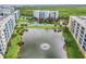 Aerial view of a condo complex with a large pond with fountain surrounded by lush, green landscaping at 5300 S Atlantic Ave # 16-205, New Smyrna Beach, FL 32169