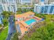 Aerial view showcases a community pool, spa, and lush landscaping near pristine beaches and modern buildings at 5300 S Atlantic Ave # 16-205, New Smyrna Beach, FL 32169