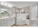 Bathroom showcasing white cabinets, a soaking tub, and walk-in shower at 5300 S Atlantic Ave # 16-205, New Smyrna Beach, FL 32169