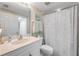 Bright bathroom with white vanity, toilet and shower with patterned curtain at 5300 S Atlantic Ave # 16-205, New Smyrna Beach, FL 32169